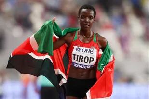 Agnes Tirop festeja con la bandera de su país, Kenia, tras conseguir la medalla de plata en el mundial de Atletismo de Doha 2019; la atleta apareció muerta en su domicilio con signos de haber sido apuñalada.