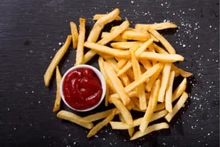 Papas fritas estilo french fries con ketchup.