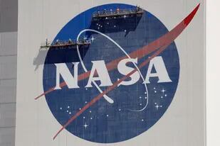 ARCHIVO - Trabajadores en un andamio repintan el logotipo de la NASA cerca de la parte superior del edificio de ensamblaje de vehículos en el Centro Espacial Kennedy el miércoles 20 de mayo de 2020 en Cabo Cañaveral, Florida. (AP Foto/John Raoux, Archivo)
