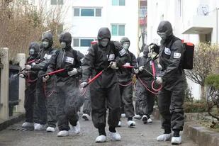 Soldados del ejército rocían desinfectante como precaución contra el nuevo coronavirus en un complejo de apartamentos en Daegu, Corea del Sur