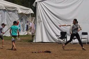 Una joven ucraniana advierte a los niños en una pelea de globos de agua que no le lancen uno, el martes 24 de mayo de 2022, en un campamento en la demarcación Iztapalapa de Ciudad de México. (AP Foto/Marco Ugarte)