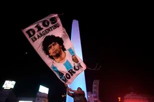 Un individuo agita una bandera con la imagen de Diego Maradona, el miércoles 25 de noviembre de 2020, en Buenos Aires. (AP Foto/Victor Caivano)