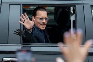 El actor Johnny Depp saluda a sus seguidores al salir del Tribunal del Condado de Fairfax (Foto AP/Craig Hudson)