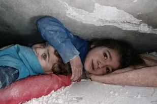 La historia detrás de la emocionante imagen de una niña que protege a su hermano menor entre los escombros en Siria - LA NACION