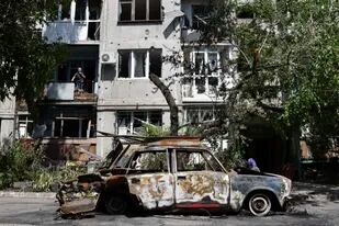 Un auto destruido está junto a un edificio residencial dañado por un misil en Sloviansk, Ucrania, 31 de mayo de 2022. (AP Foto/Andriy Andriyenko)
