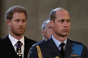 El príncipe Harry (izquierda) de Gran Bretaña, duque de Sussex, y el príncipe Guillermo (derecha) de Gran Bretaña, príncipe de Gales, reaccionan cuando el ataúd de la reina Isabel II de Gran Bretaña llega al Palacio de Westminster, luego de una procesión desde el Palacio de Buckingham, en Londres