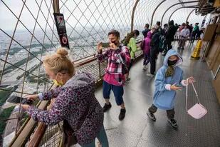 ARCHIVO - En esta imagen de archivo del viernes 16 de julio de 2021, gente mirando la vista desde la Torre Eiffel en París. (AP Foto/Michel Euler, Archivo)