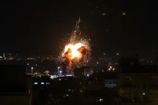 Fuego y humo se elevan sobre los edificios de la ciudad de Gaza mientras Israel lanza ataques aéreos sobre el enclave palestino en la madrugada del 27 de enero de 2023.