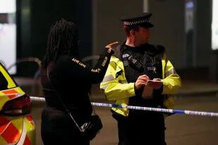 Una persona habla con un oficial de policía, en Reading, Gran Bretaña, donde ocurrió el último incidente