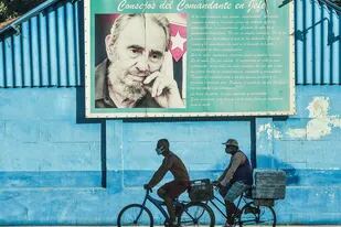 Ciclistas frente a un mural de Fidel Castro en La Habana