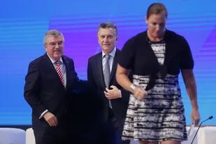 Thomas Bach y Mauricio Macri, precedidos por la lanzadora de martillo Jennifer Dahlgren, que los entrevistó en la apertura del foro