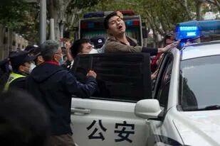 La policía se lleva a un manifestante en medio de una protesta en Shanghái, la semana pasada