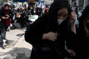 Mujeres que participaban de la protesta huyen tras los disparos al aire de los milicianos talibanes