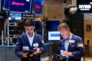 En esta fotografía proporcionada por la Bolsa de Valores de Nueva York, los corredores Orel Partush (izquierda) y Robert Charmak trabajan, el viernes 10 de junio de 2022. (David L. Nemec/New York Stock Exchange via AP)
