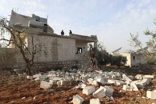 Gente inspecciona una casa destruida tras una incursión militar de Estados Unidos en la aldea de Atmeh, Siria, jueves 3 de febrero de 2022.  En la incursión murió el dirigente de SIS Abu Ibrahim al-Hashimi al-Qurayshi. (AP Foto/Ghaith Alsayed)