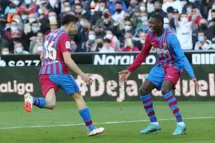 Pedri celebra con Ousmane Dembélé tras anotar el cuarto gol del Barcelona en el partido contra Valencia por la Liga española