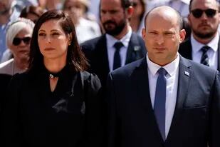 El primer ministro israelí Naftali Bennett y su esposa Gilat participan de una ceremonia en el Día de Recordación del Holocausto en el monumento Yad Vashem, Jerusalén, jueves 28 de abril de 2022. (Amir Cohen/Pool Photo via AP)