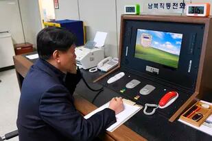 En esta imagen del 3 de enero de 2019, un funcionario del gobierno de Corea del Sur se comunica con un funcionario norcoreano durante una llamada telefónica en una línea especializada en la localidad fronteriza de Paju, Corea del Sur. (Ministerio de Unificación de Corea del Sur/Yonhap vía AP, archivo)