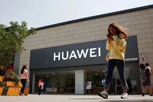 Una mujer pasa frente a un local de Huawei en Pekín