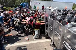 Migrantes rompen una fila de la Guardia Nacional que intenta impedirles salir de Tapachula, México, el viernes 1 de abril de 2022. (AP Foto/Edgar H. Clemente)