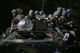 Los soldados ucranianos se sientan en un vehículo blindado de transporte de personal (APC) en su camino hacia la línea del frente contra las tropas rusas en la región de Donetsk, el 21 de septiembre de 2022. (Anatolii Stepanov / AFP)