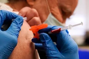 El farmacéutico Kenni Clark inyecta a Robert Champion con una dosis de refuerzo de la vacuna contra el COVID-19 desarrollada por Moderna en una clínica de Lawrence, Massachusetts (AP/Charles Krupa)