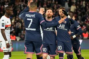 Lionel Messi (centro) celebra con Neymar (derecha) y Kylian Mbappé tras anotar el cuarto gol del Paris Saint Germain en la victoria 5-1 ante Lorient en la liga francesa, el domingo 3 de abril de 2022. (AP Foto/Michel Euler)