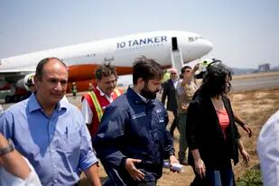 El presidente chileno Gabriel Boric camina cerca del avión 10 Tanker, que llevará agua para rociar sobre los incendios forestales, mientras se llena de agua en el aeropuerto de Talcahuano, Chile, el lunes 6 de febrero de 2023.