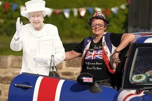 La monárquica Anita Atkinson, que tiene más de 12.000 objetos de recuerdo, camino de una fiesta en Durham, Inglaterra, el jueves 2 de junio de 2022, en el primero de los cuatro días de celebraciones del Jubileo de Platino de la reina Isabel II. (Owen Humphreys/PA via AP)