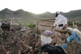 Un hombre se para entre escombros después de un sismo en el poblado de Gayan, en la provincia de Paktiká, Afganistán, el jueves 23 de junio de 2022. (AP Foto/Ebrahim Nooroozi)