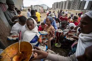 ARCHIVO - Desplazados de Tigray hacen fila para recibir alimentos donados por residentes locales en un centro de recepción para desplazados internos en Mekele, en la región de Tigray, en el norte de Etiopía, el 9 de mayo de 2021. (AP Foto/Ben Curtis, Archivo)