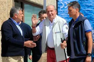 El rey emérito de España, Juan Carlos, en el centro, saluda antes de una recepción en un club náutico antes de una regata en Sanxenxo, en el noroeste de España, el viernes 20 de mayo de 2022. (AP Foto/Lalo R. Villar)