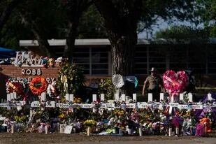 ARCHIVO - Flores y velas en un sitio de homenaje afuera de la Escuela Primaria Robb para honrar a las víctimas de un tiroteo en la institución, en Uvalde, Texas, el sábado 28 de mayo de 2022. (AP Foto/Jae C. Hong, Archivo)