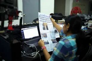 Una periodista sostiene una copia del diario independiente La Prensa, cuando todavía funcionaba en su sede, ahora también expropiada.