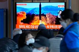 Varias personas miran una televisión que muestra una imagen de archivo de un lanzamiento de un misil norcoreano, el domingo 27 de febrero de 2022, en la Estación Ferroviaria de Seúl, Corea del Sur. (AP Foto /Ahn Young-joon)