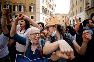 La gente se reúne frente al Palacio de Montecitori para participar en una protesta contra la obligación de vacunarse contra el coronavirus, en Roma
