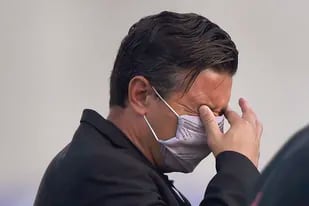 El técnico de River Plate, Marcelo Gallardo, se frota los ojos, al resentir los gases lacrimógenos rociados en las inmediaciones del estadio en Barranquilla, antes de un partido de la Copa Libertadores ante el local Junior, el miércoles 12 de mayo de 2021 (Daniel Muñoz/Pool via AP)