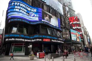 ARCHIVO - Una pantalla electrónica muestra noticias el miércoles 11 de marzo de 2020 en Times Square, Nueva York. Un nuevo sondeo publicado el 15 de febrero de 2023 mostraba que la mitad de los estadounidenses cree que los medios nacionales intentan desinformar, engañar o convencer al público de que tome un punto de vista. (AP Foto/Mary Altaffer, Archivo)