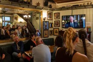 En un pub en Londres, británicos siguen con atención el primer discurso del rey Carlos III. (AP Photo/Bernat Armangue)