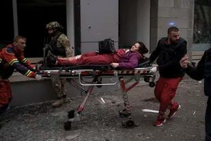 Una mujer es trasladada a una ambulancia tras resultar herida en un bombardeo ruso en Járkiv, Ucrania, el domingo 17 de abril de 2022. (AP Foto/Felipe Dana)