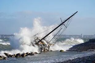 Las olas chocan contra un velero en Elsinore, Dinamarca, el domingo 30 de enero de 2022, caído por la tormenta Malik