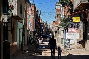 Una mujer y un niño caminan por una calle en la Villa 21-24 en Buenos Aires el 29 de septiembre de 2020