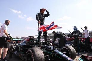 Lewis Hamilton celebra con la bandera británica la victoria en Silverstone; los neumáticos del Mercedes enseñan la dureza de la batalla