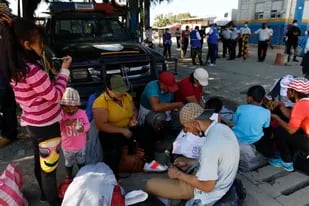 Migrantes que forman parte de una caravana que aspira con llegar a Estados Unidos se toman un descanso en Corinto, Honduras, el sábado 15 de enero de 2022. (AP Foto/Delmer Martínez)