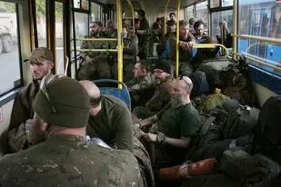 Combatientes ucranianos se sientan en un autobús tras ser evacuados de la asediada planta metalúrgica de Azovstal de Mariúpol, cerca de una prisión en Olyonivka, en territorio controlado por la República Popular de Donetsk, en el este de Ucrania, el martes 17 de mayo de 2022. (AP Foto)