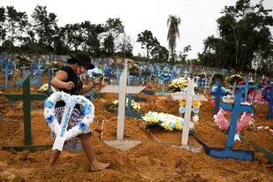 Una mujer camina entre las tumbas, en el cementerio Parque Taruma en Manaos, Brasil
