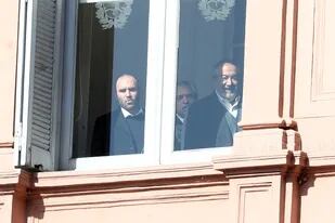 Martín Guzmán, asomado desde una ventana de la Casa Rosada junto a Daer (CGT) y el presidente Fernández