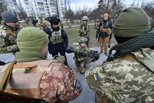 Los miembros de las Fuerzas de Defensa Territorial de Ucrania examinan nuevo armamento, incluidos los sistemas antitanque NLAW y otros lanzagranadas antitanque portátiles, en Kiev