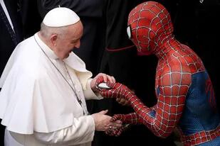 El papa Francisco recibe una máscara de Spiderman como regalo de Mattia Villardita, un joven con el traje del superhéroe que hace sonreír a los niños en las salas de pediatría de los hospitales, durante su audiencia general en el patio de San Dámaso