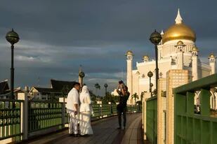 Una pareja recién casada se fotografía frente a una mezquita de la capital de Brunei